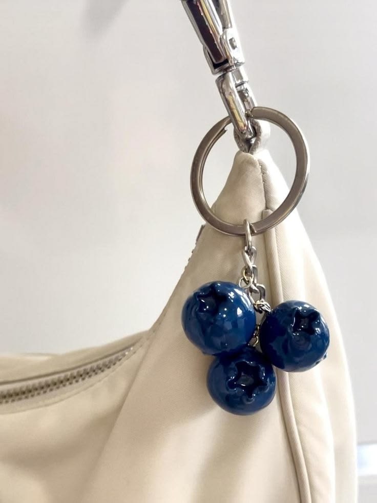 Blueberry fruit bag charm clipped to a purse as a cute blue accessory