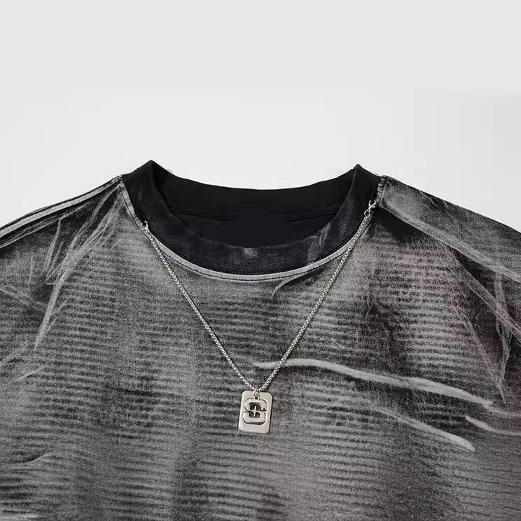 Necklace with a pendant on a gray shirt against a white background