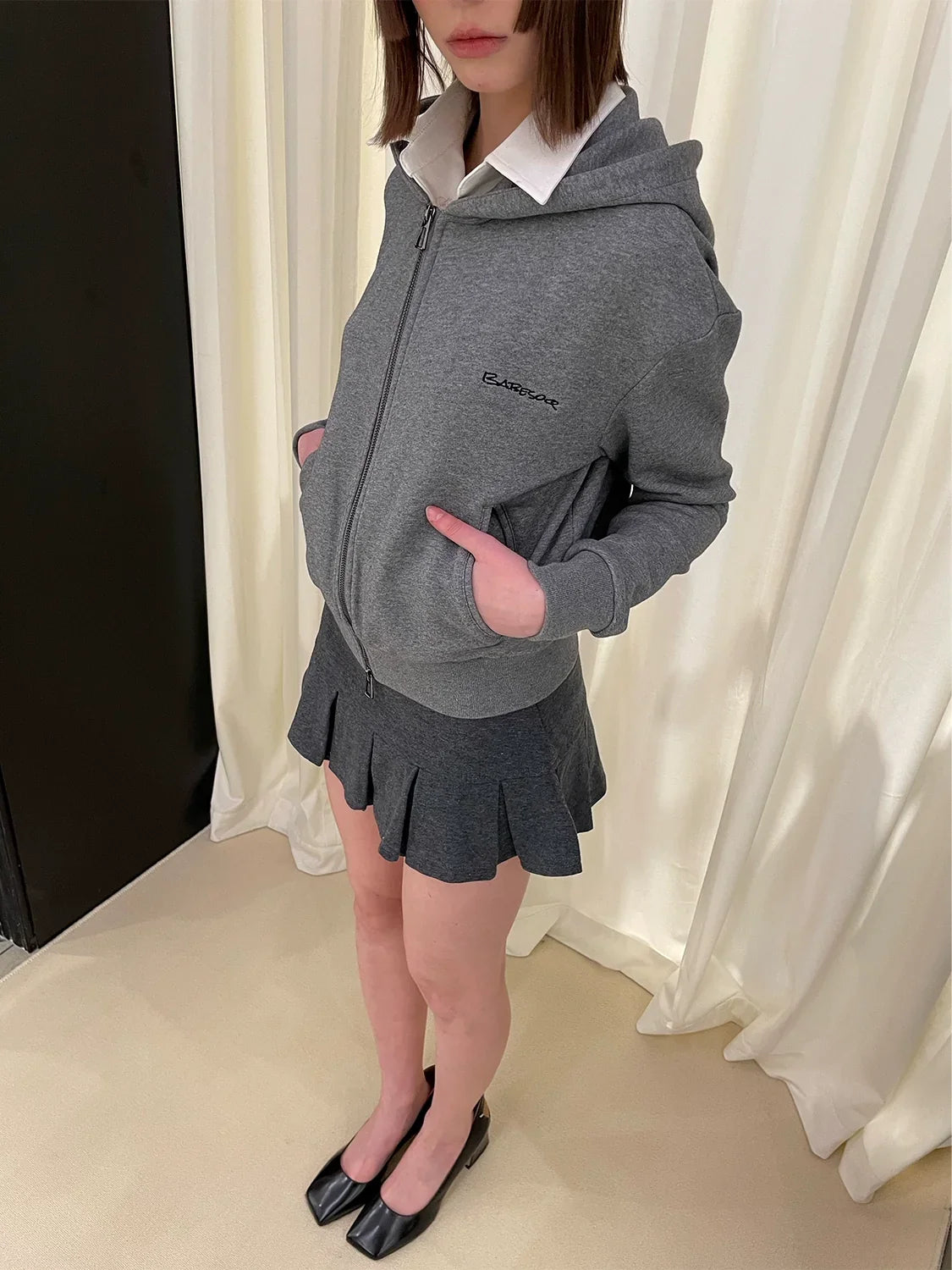 Sudadera con cremallera y falda corta plisada