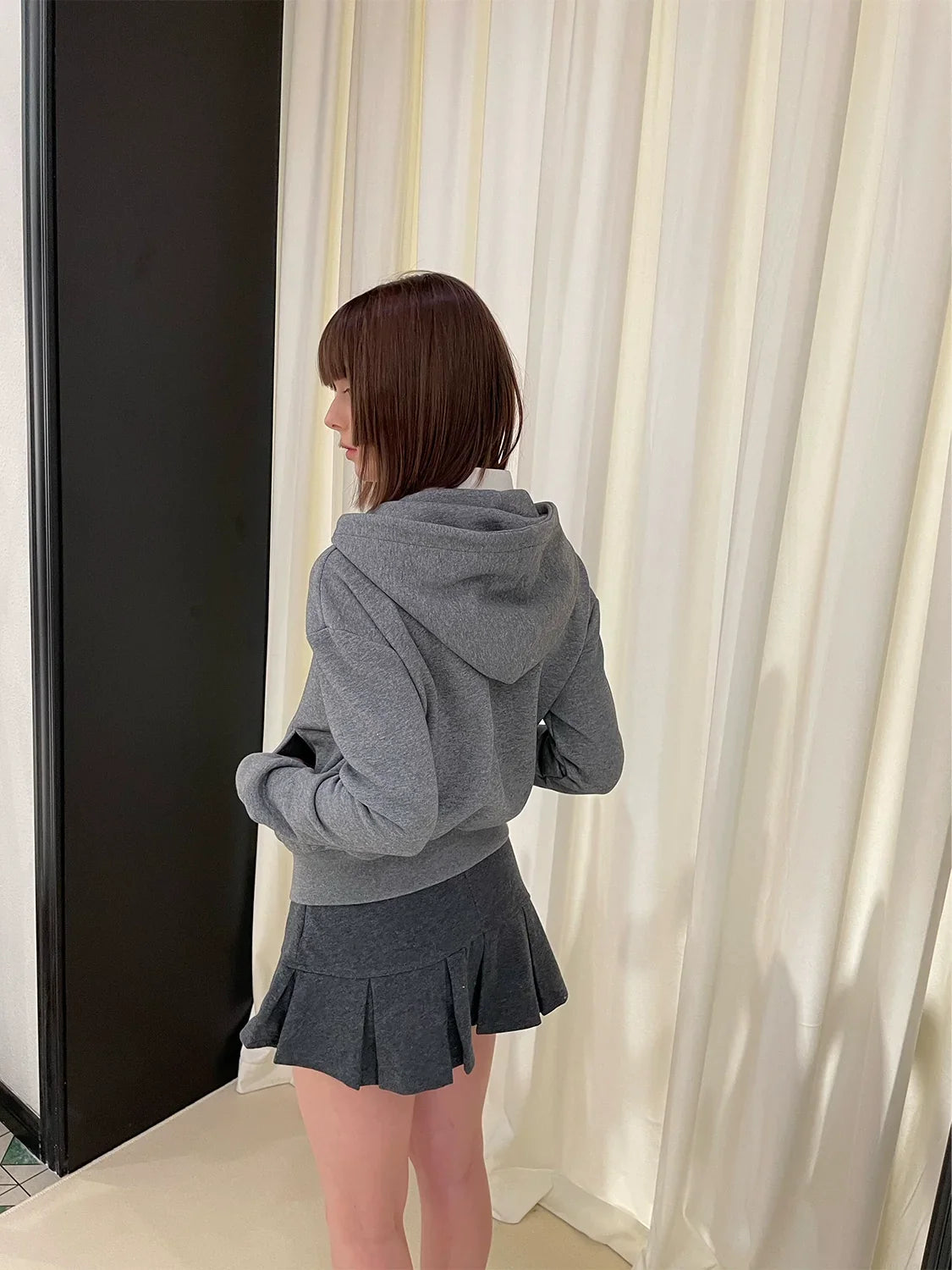 Sudadera con cremallera y falda corta plisada