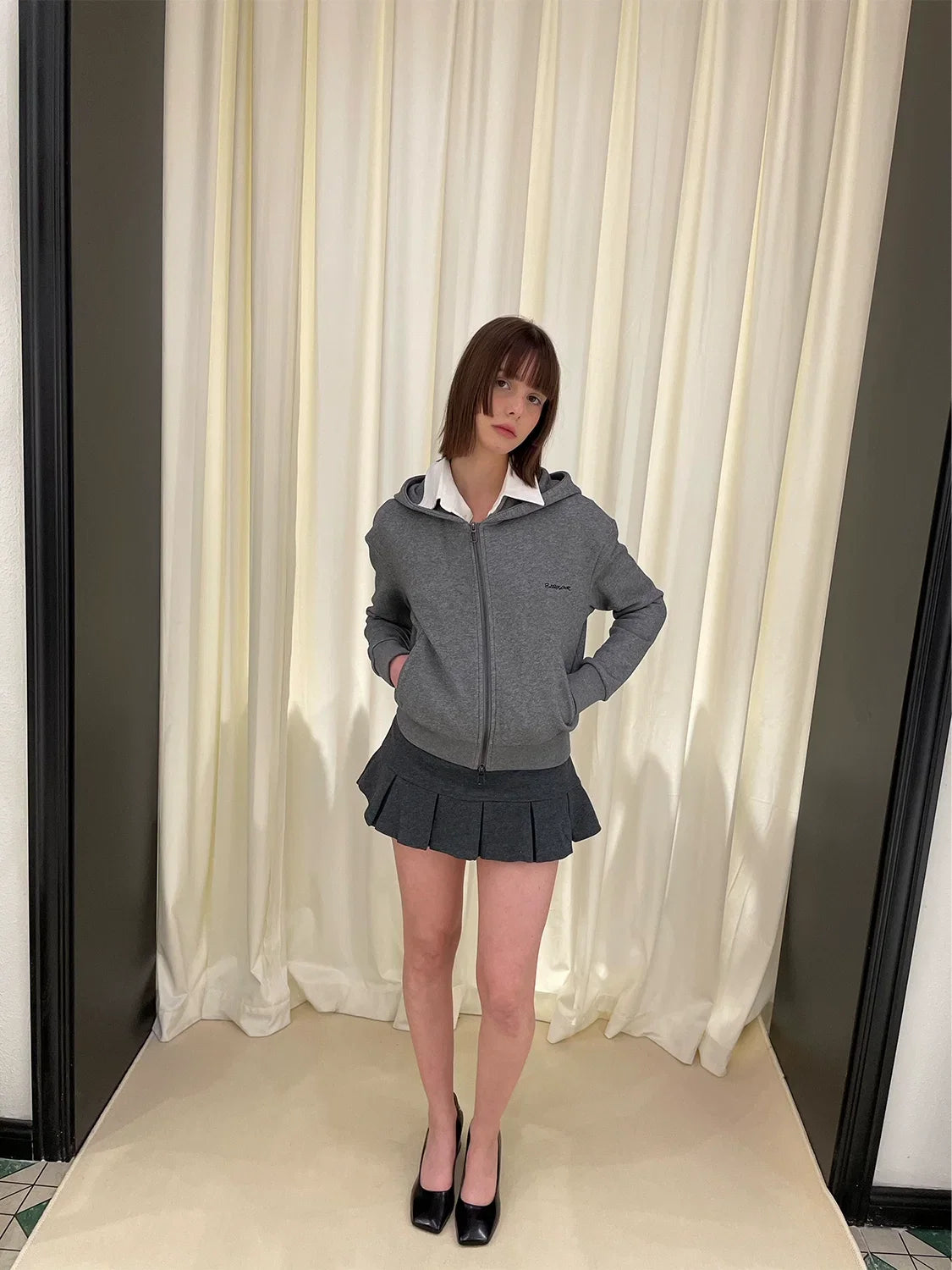 Sudadera con cremallera y falda corta plisada