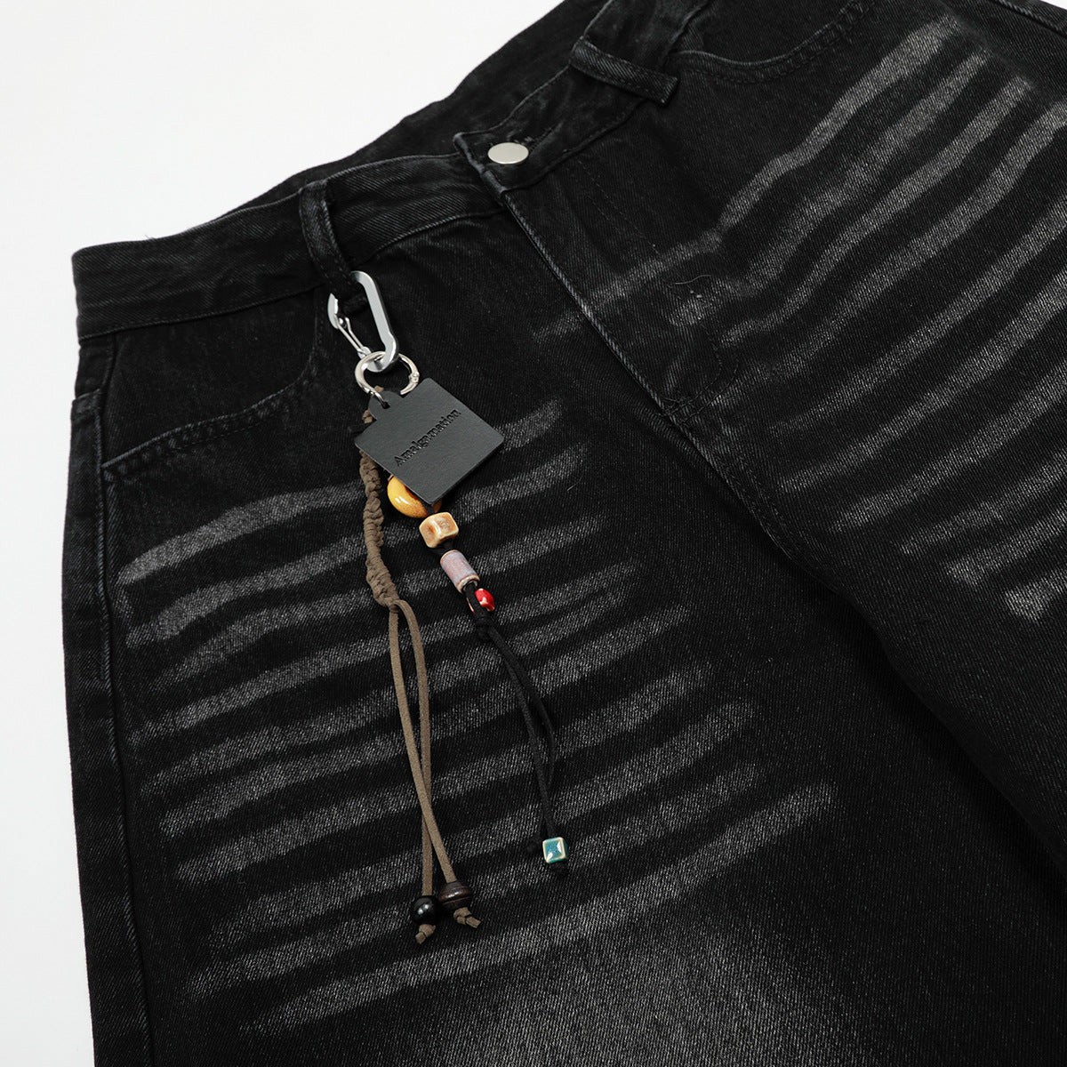 Verwaschene schwarze Wide-Leg-Jeans mit Charme-Anhänger