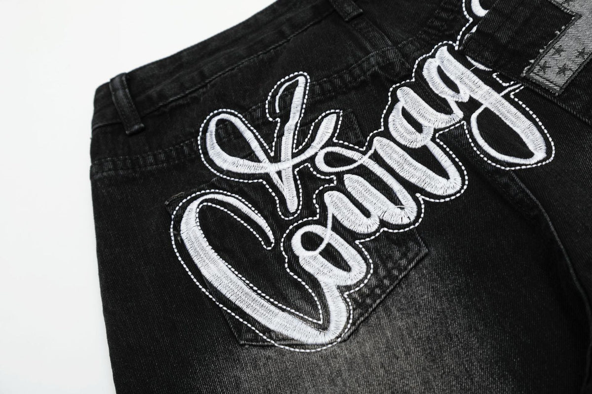 Verwaschene schwarze Wide-Leg-Jeans mit Charme-Anhänger