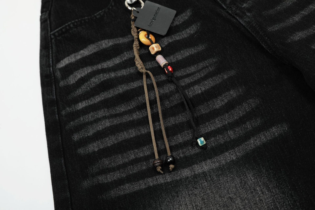 Verwaschene schwarze Wide-Leg-Jeans mit Charme-Anhänger