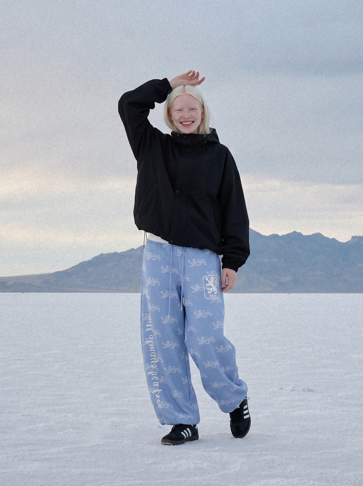 DAXUEN light blue rampant lion graphic jogging pants — model photo
